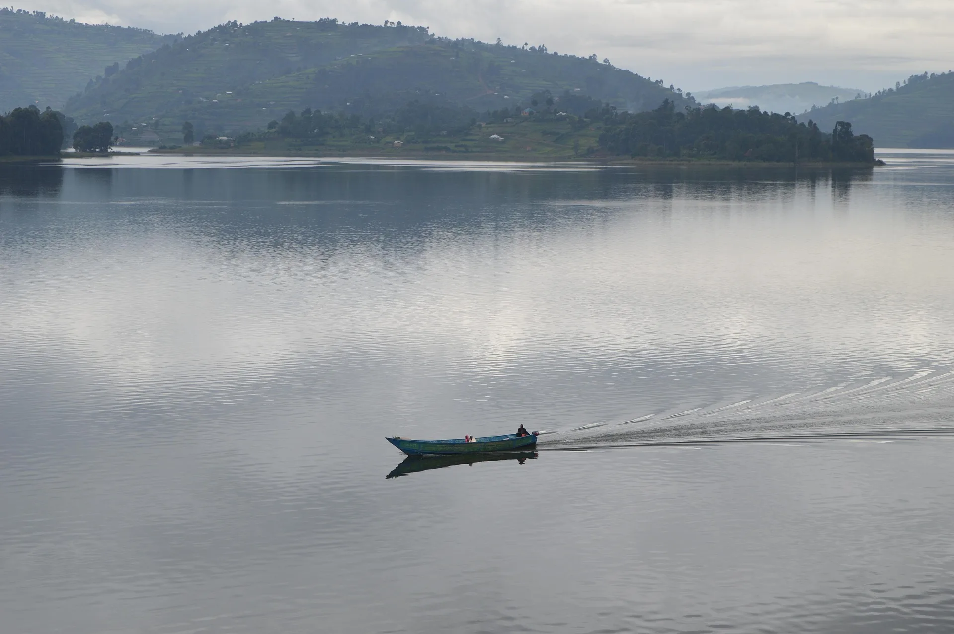 Lake Bunyonyi islands with terraced hillsides and traditional canoe at sunrise