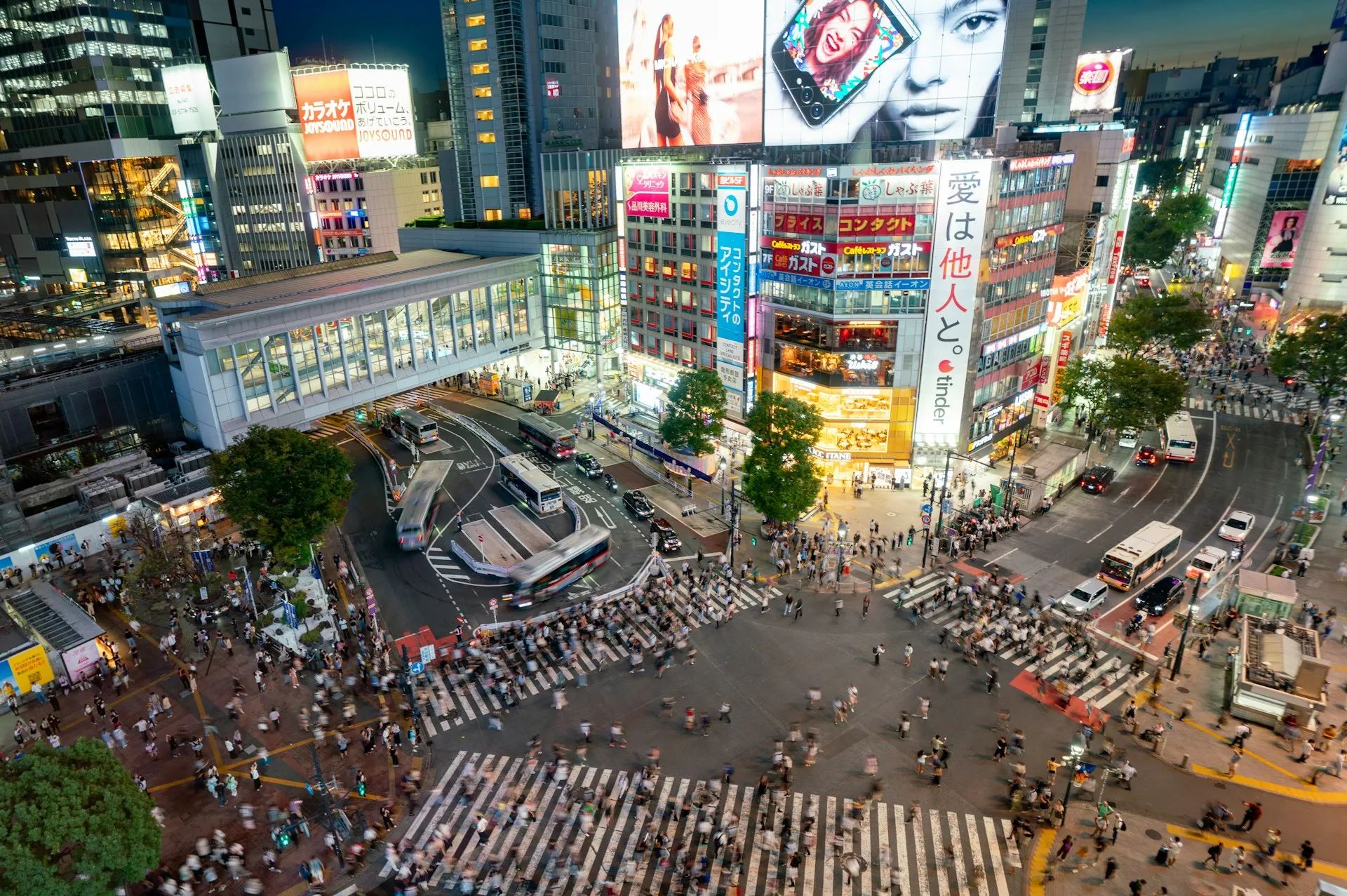 Shibuya Crossing at night with neon lights and crowds