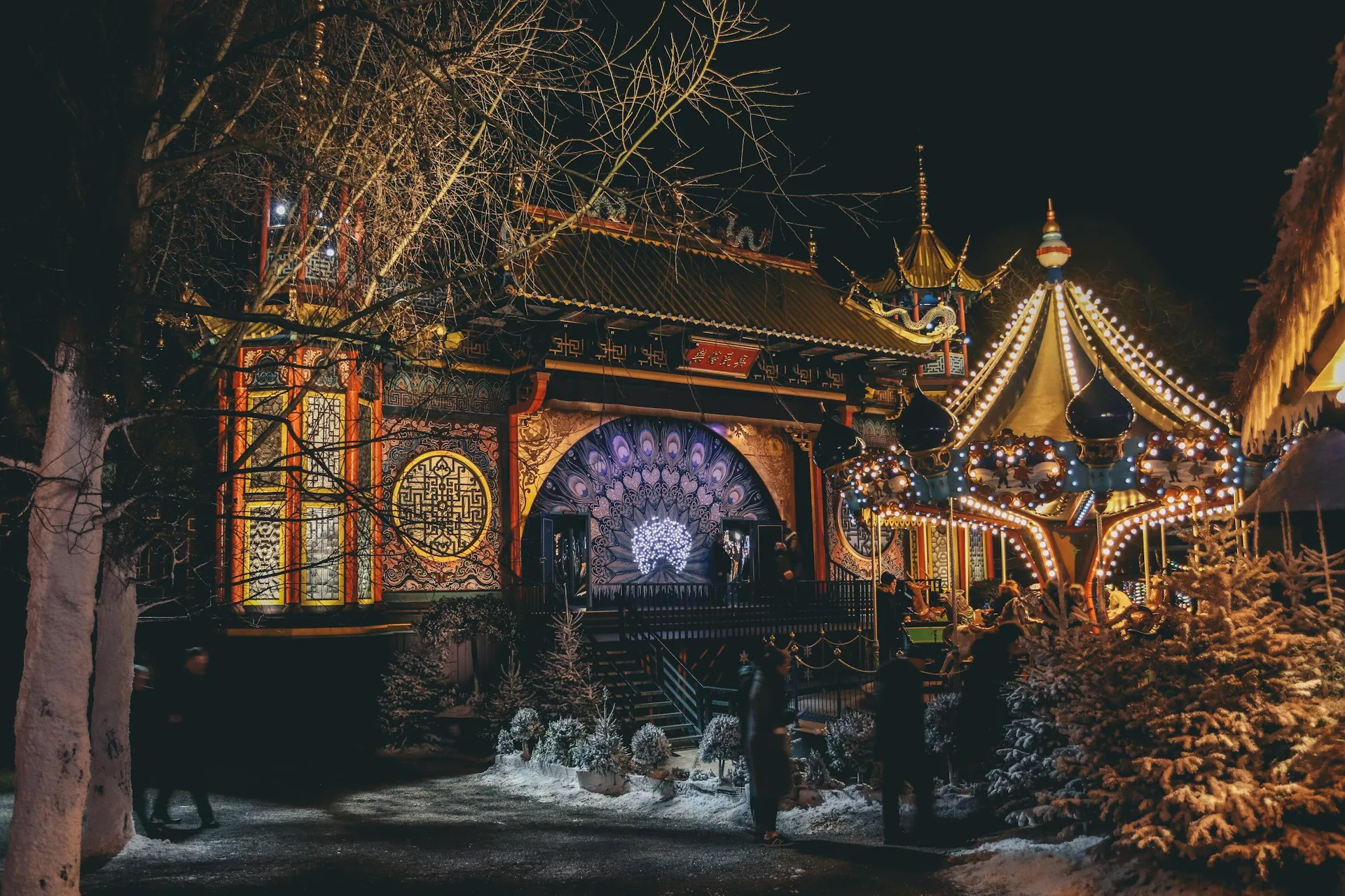 Tivoli Gardens illuminated at night with colorful lights and rides