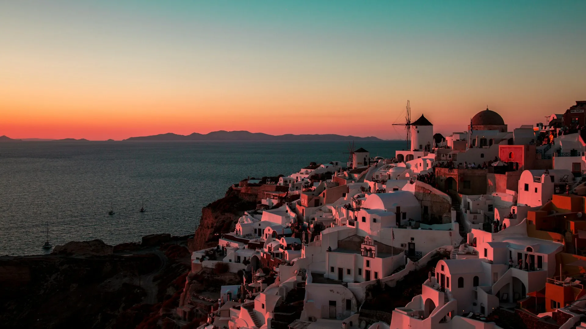 Oia sunset with blue-domed churches and caldera views in Santorini