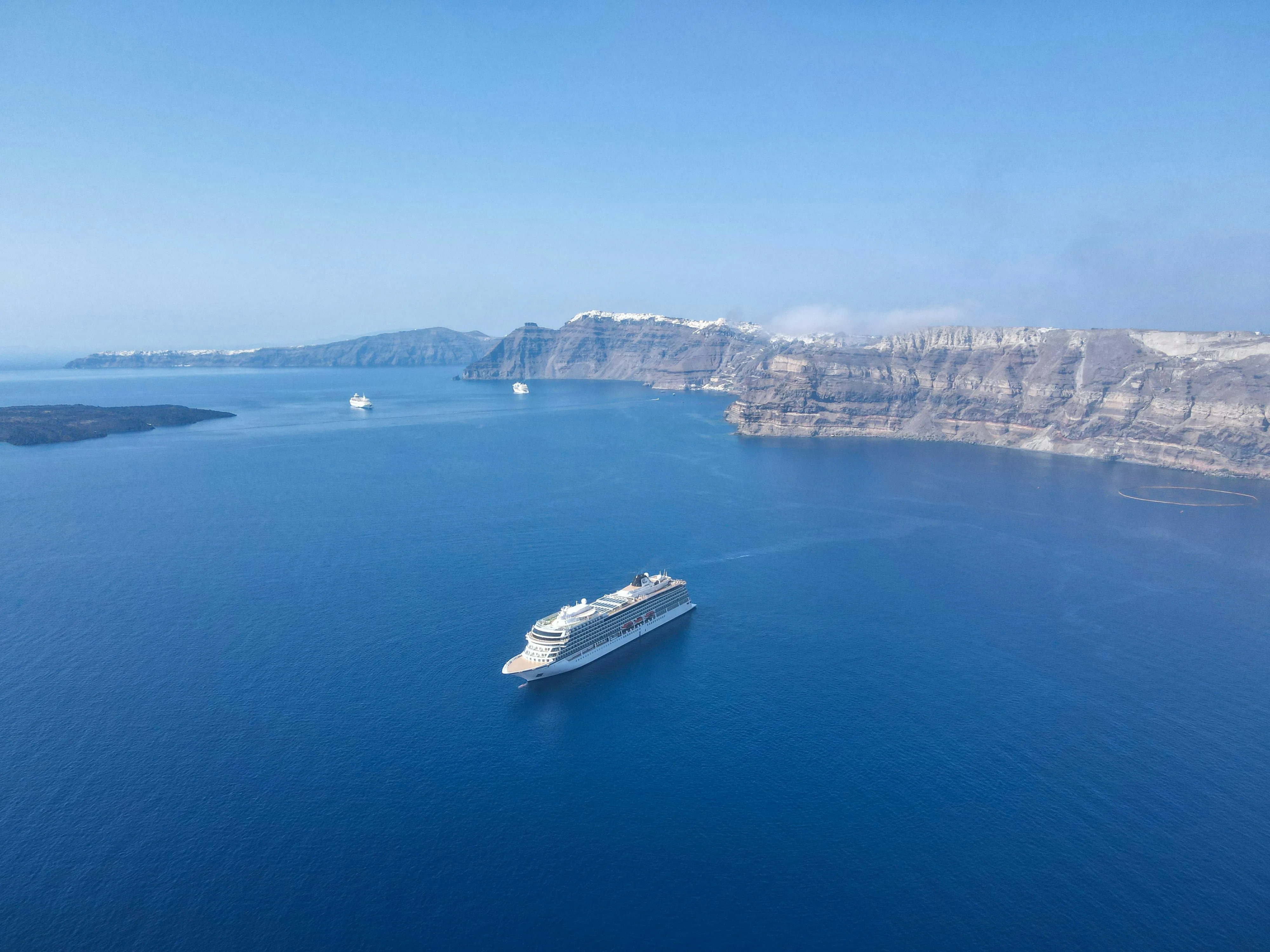 Santorini caldera cliffs and whitewashed villages viewed from boat tour