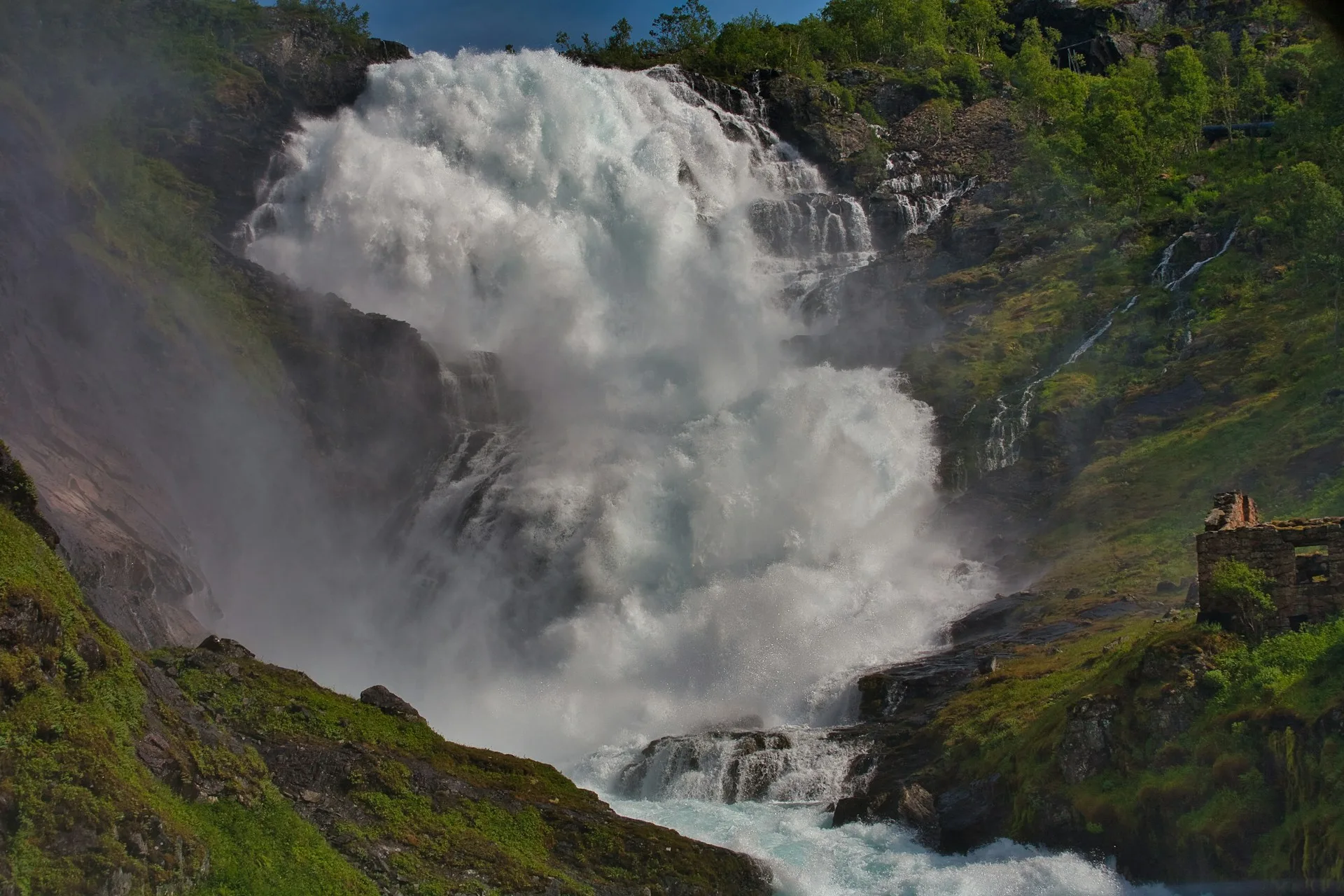 Powerful Kjosfossen waterfall cascading down mountains at Flåm Railway stop