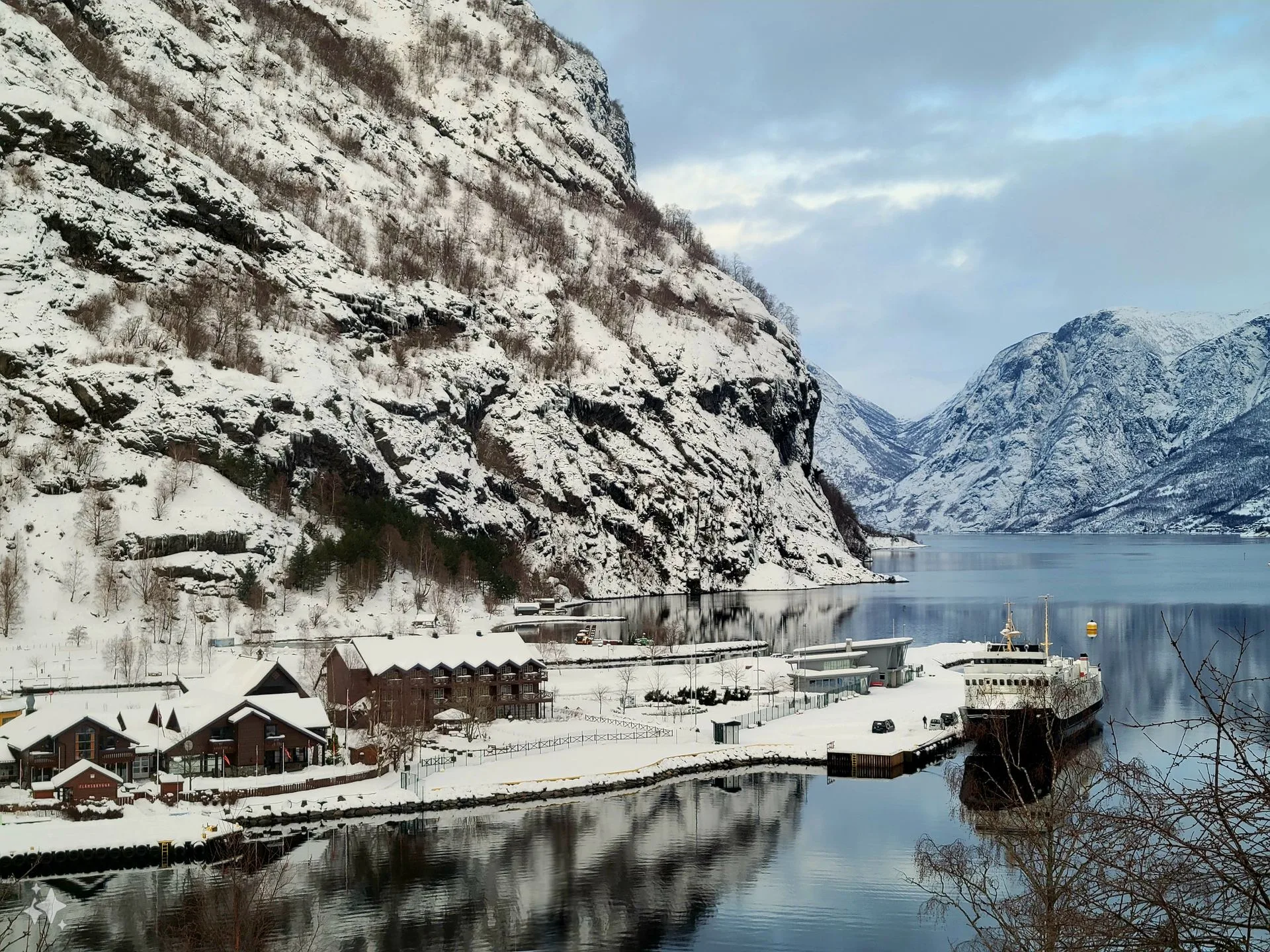 Picturesque Flåm village wooden buildings with Aurlandsfjord and mountains