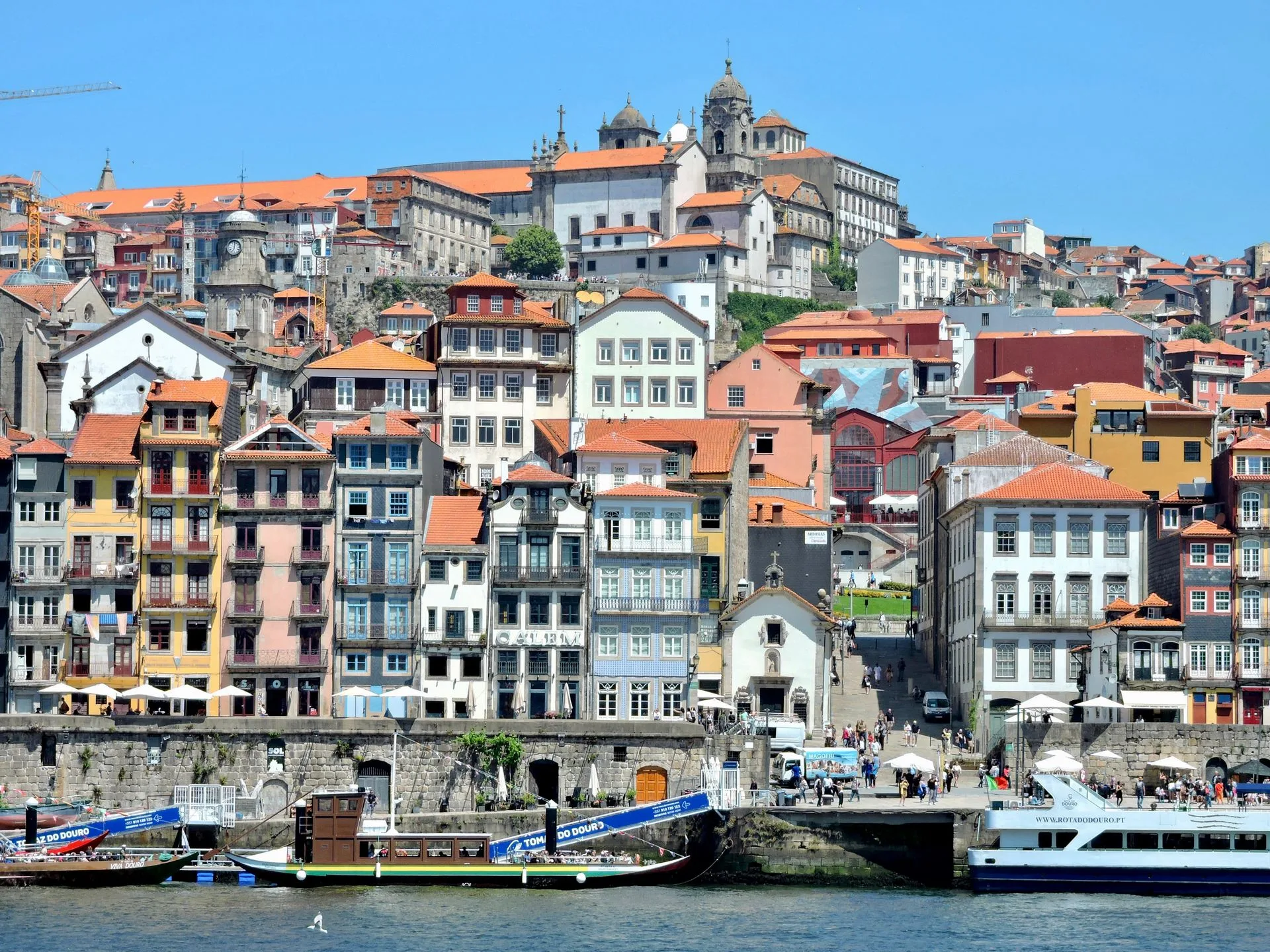 Colorful Ribeira district buildings reflected in Douro River at sunset