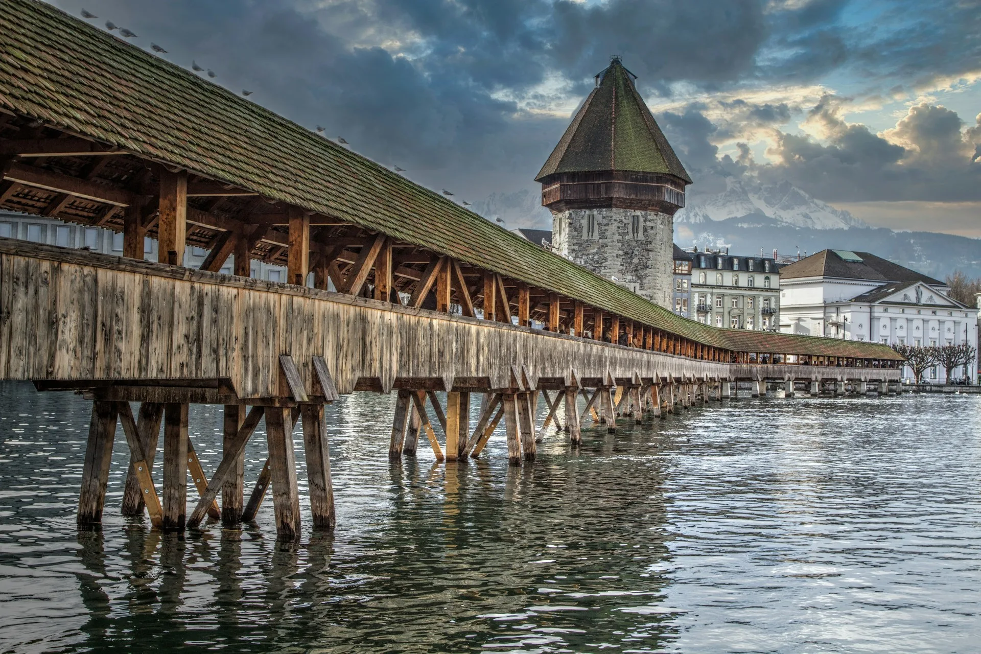 Chapel Bridge at dusk with Water Tower and mountains in Lucerne