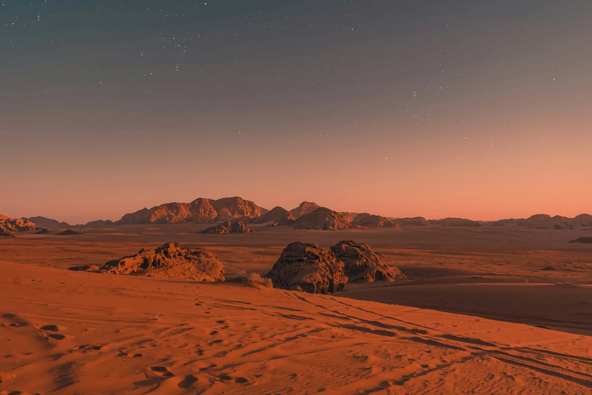 Wadi Rum desert sunset with red sandstone mountains and golden sand dunes