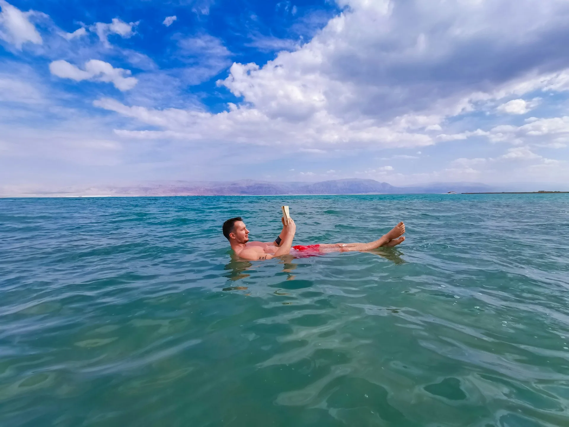 Dead Sea floating experience with therapeutic mineral-rich waters and mountain backdrop