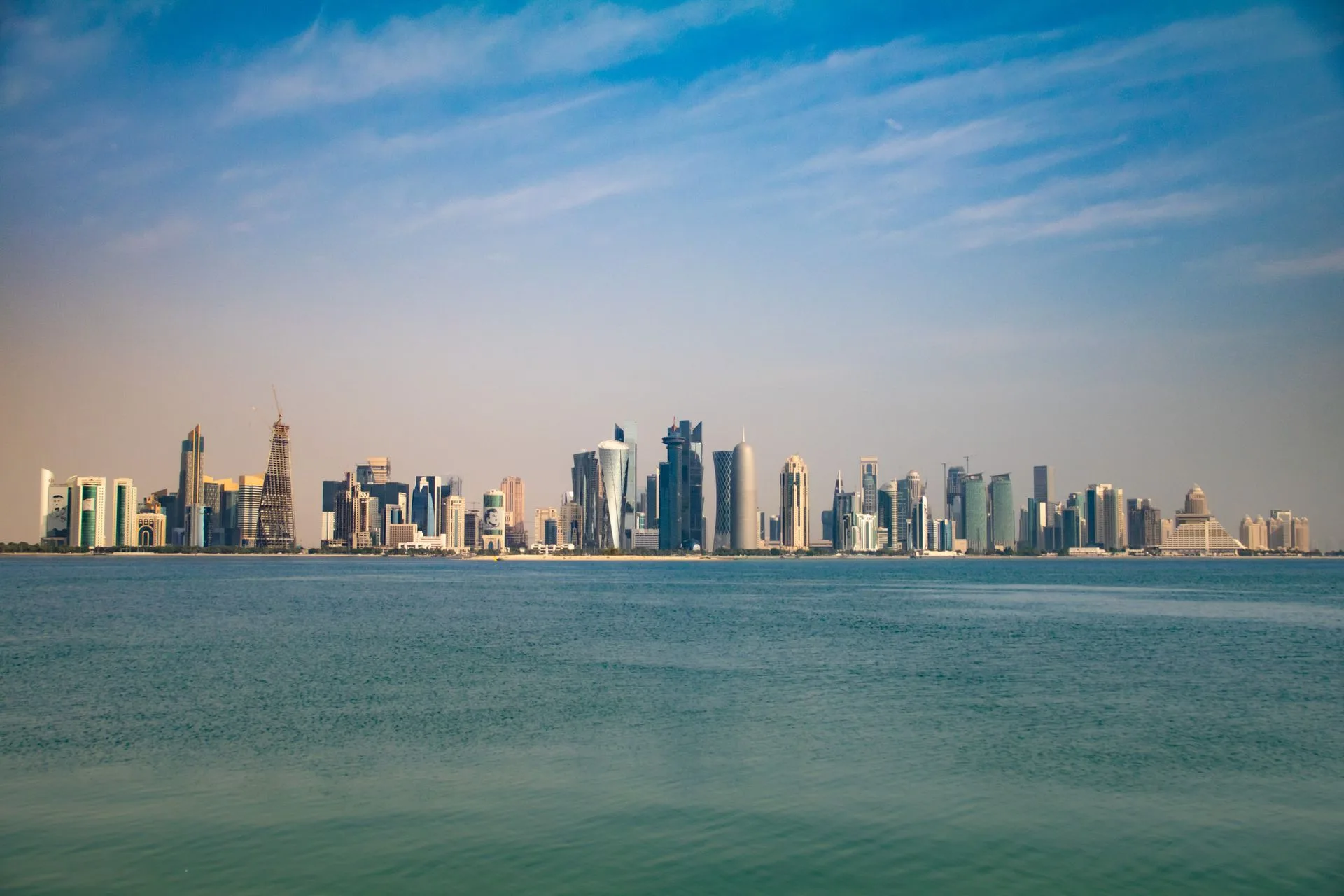 Illuminated West Bay skyline from Doha Corniche at twilight