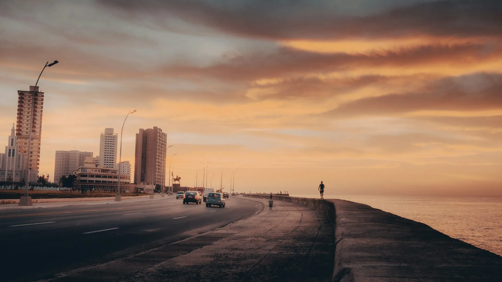 Malecon sunset with waves and Havana skyline silhouette