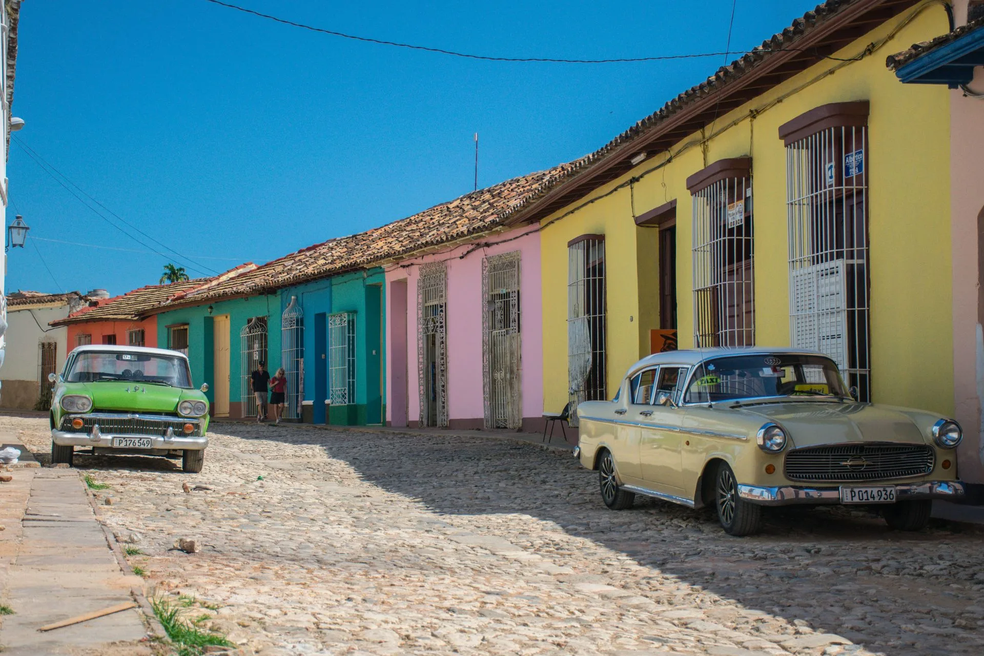 Trinidad cobblestone streets with colorful colonial houses and vintage cars