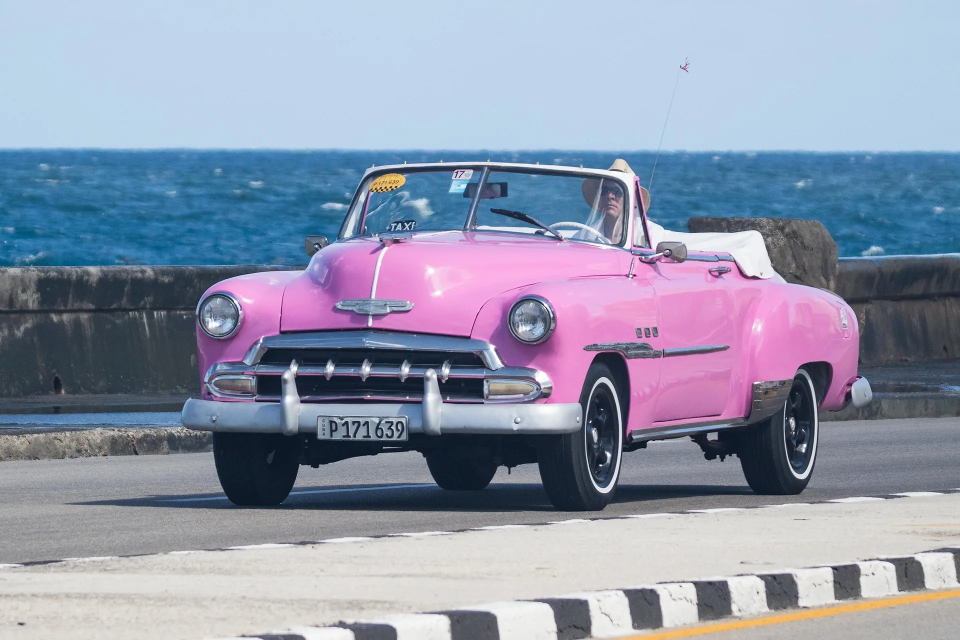 Colorful vintage American cars in Havana with colonial architecture background
