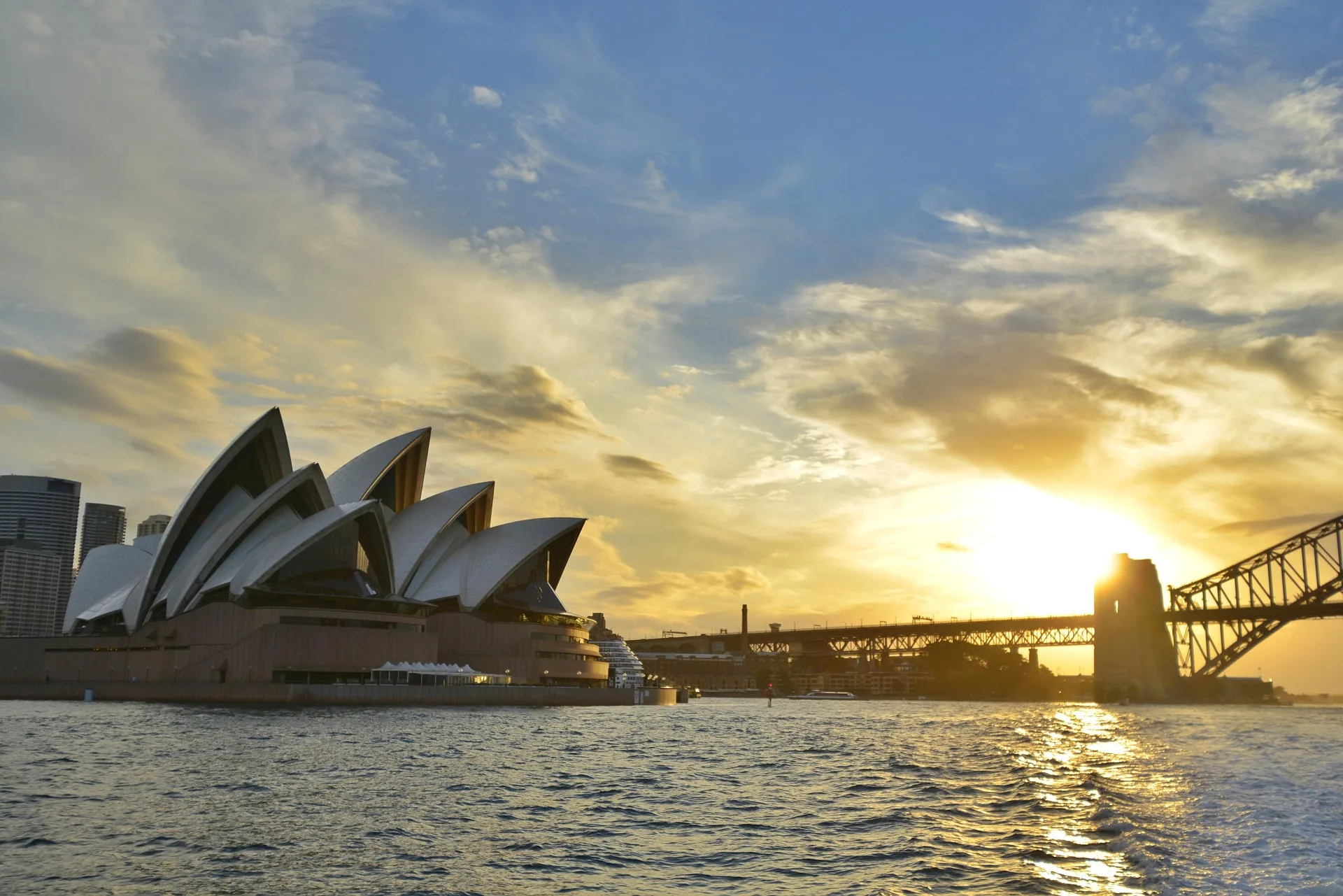 Sydney Opera House at sunrise with harbor reflections