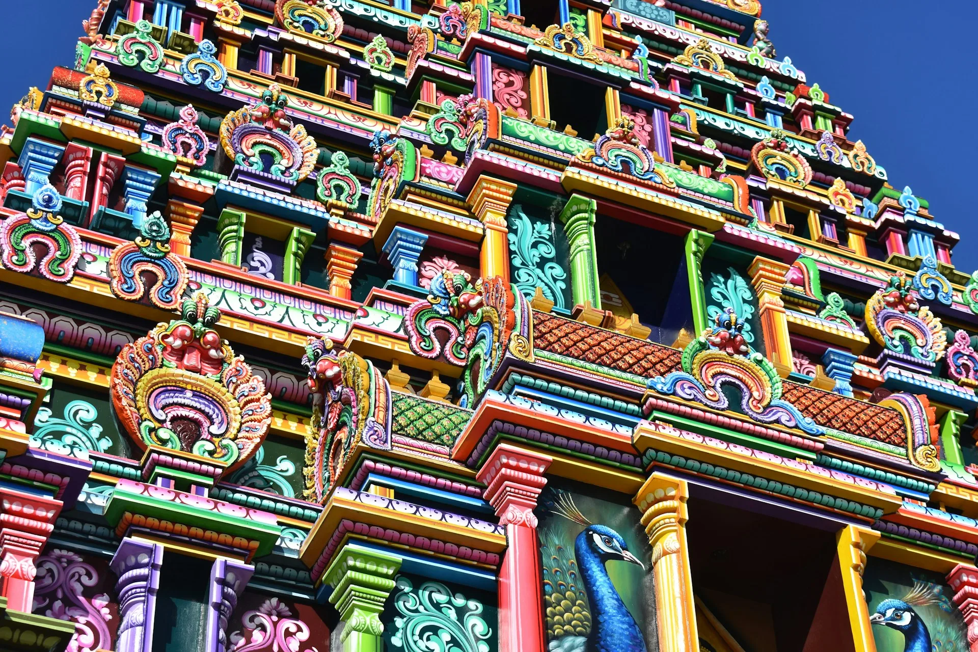 Colorful Hindu temple exterior with ornate architecture and family