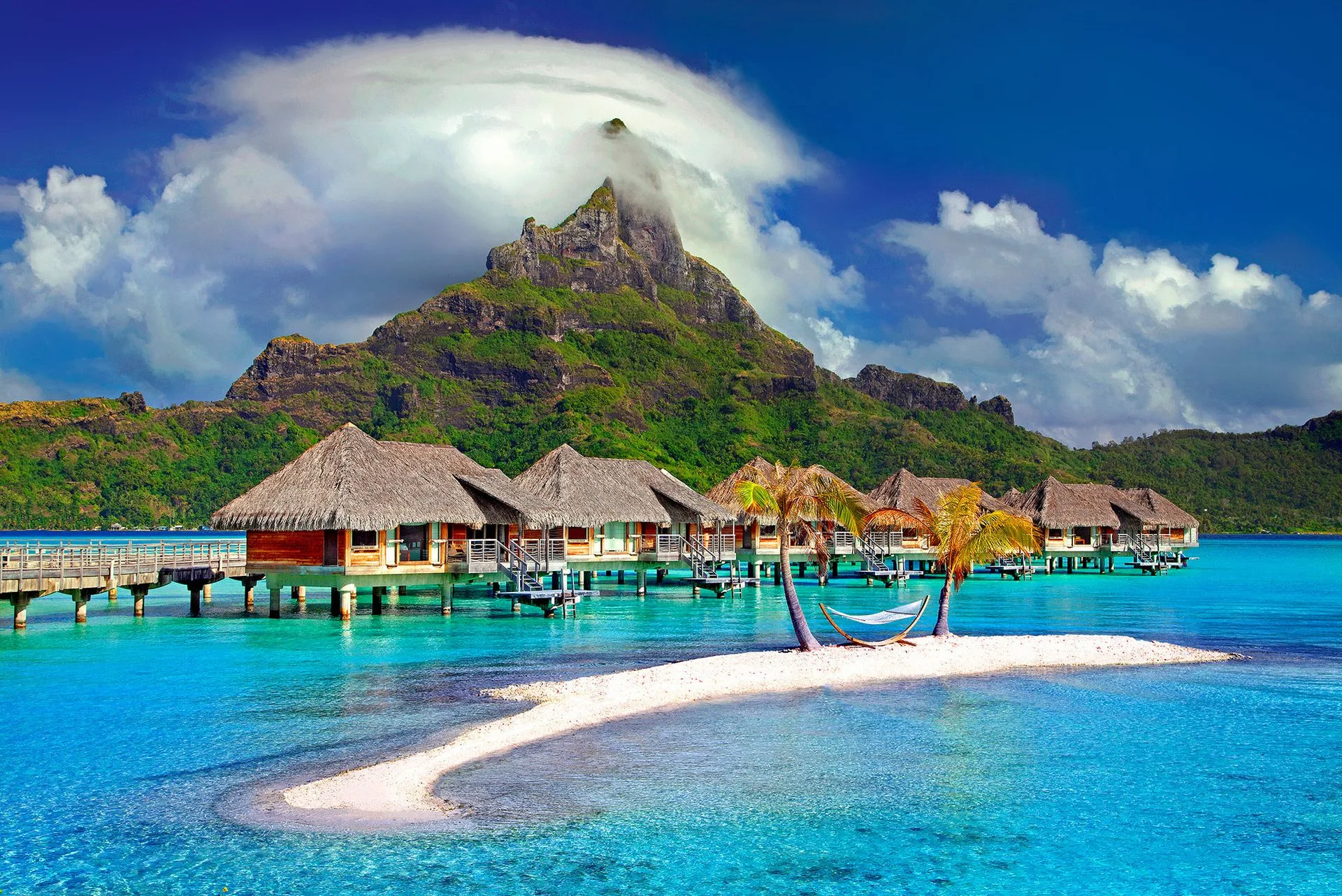 Family standing on lagoon sandbar with mountains
