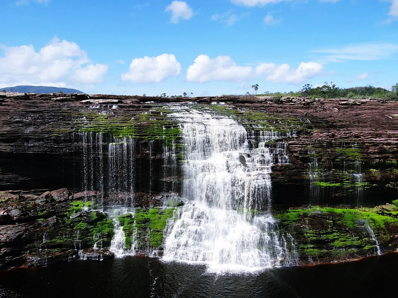 Path behind cascading Salto El Sapo waterfall with jungle visible through water