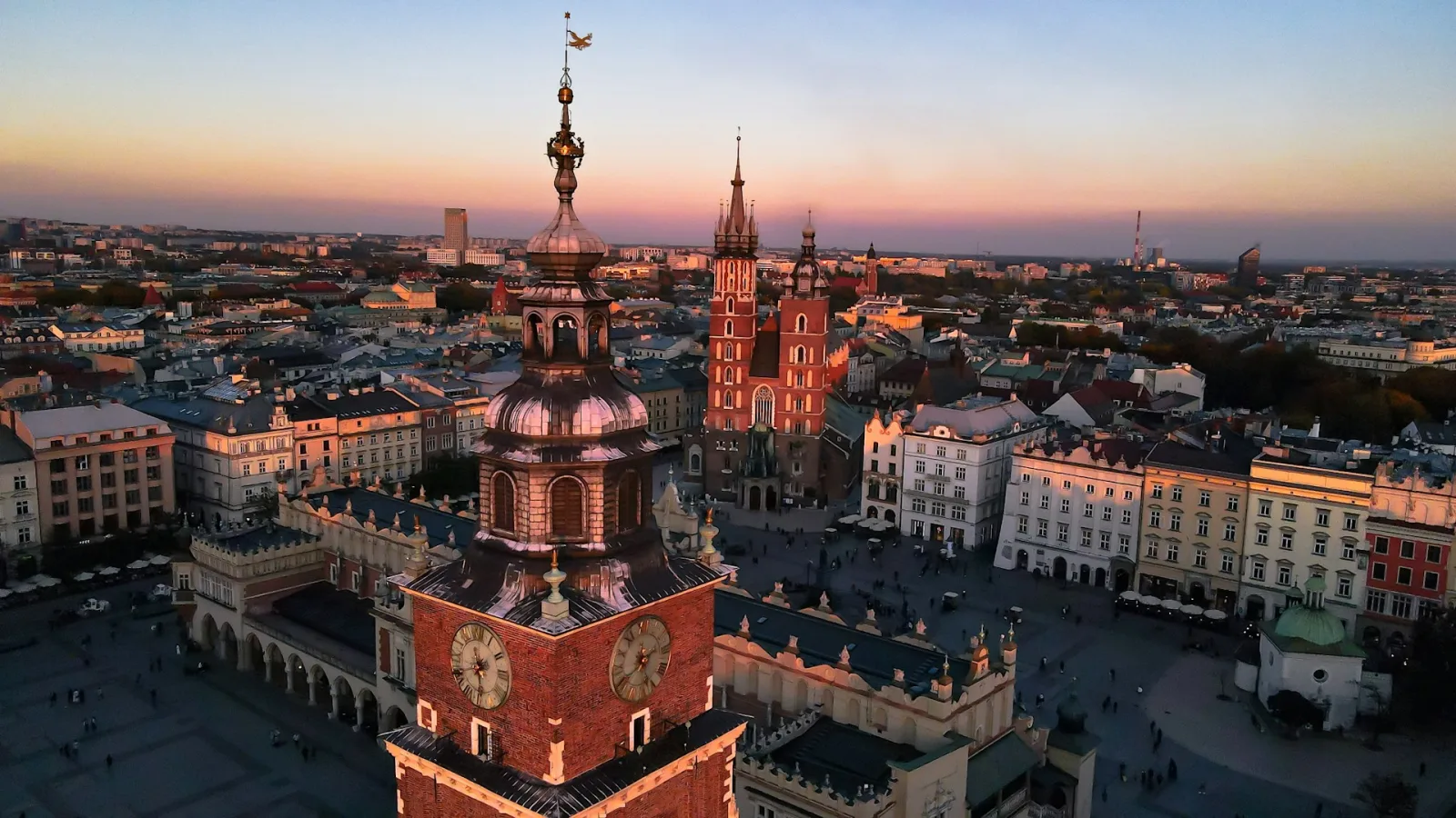 Kraków Main Market Square at dusk with St. Mary's Basilica and Cloth Hall illuminated